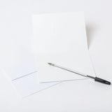 Blank greeting card with a pen on a white background.