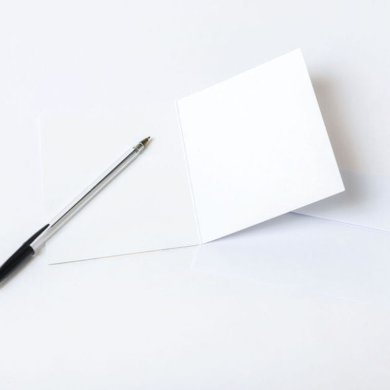 White paper with a pen on a white background