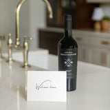 Bottle of wine on a kitchen counter with a 'Welcome home' greeting card.