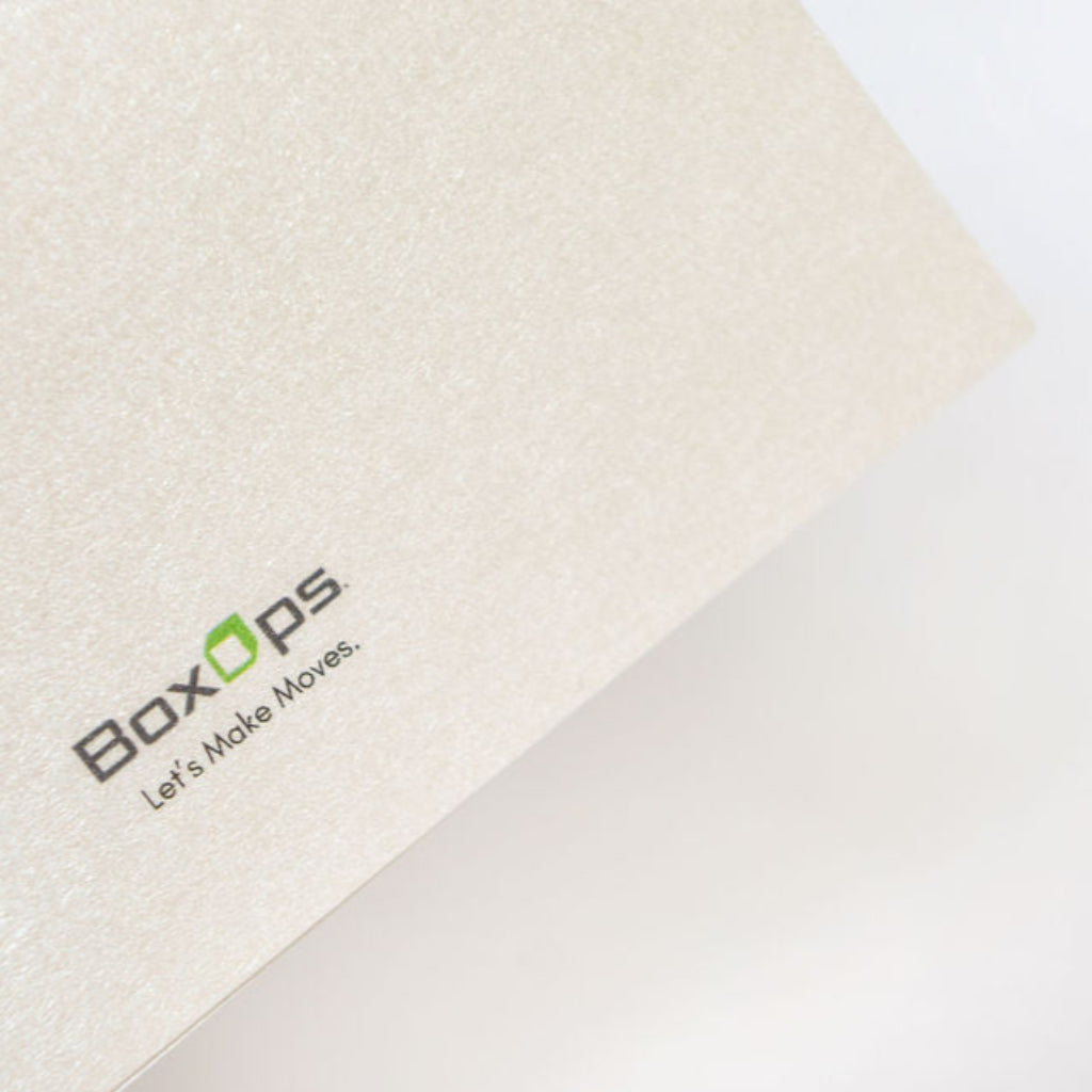 BoxOps logo on the back of a textured premium pearl greeting card for moving & new homeowners.