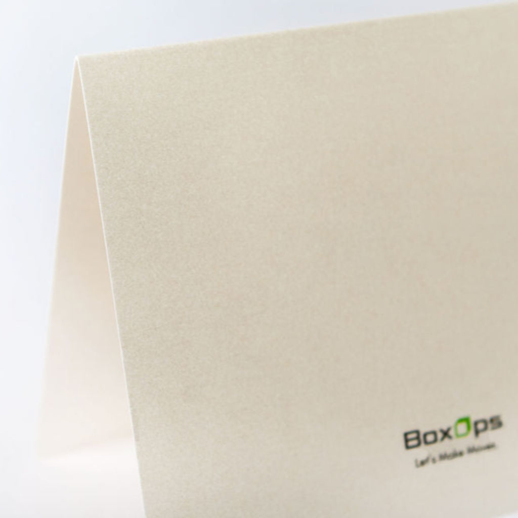 Greeting card close-up shot showing the premium pearl shimmer material, with a BoxOps logo printed on it.