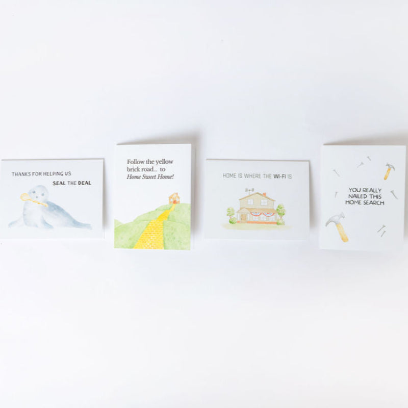 Four greeting cards with hand drawn illustrations for moving and real estate laying on a white background
