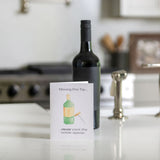 Wine bottle on a kitchen counter with a card about moving tips.