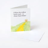 Greeting card with a yellow brick road illustration and text on a white background