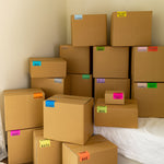 stack of brown moving boxes labeled with color coded moving stickers by BoxOps