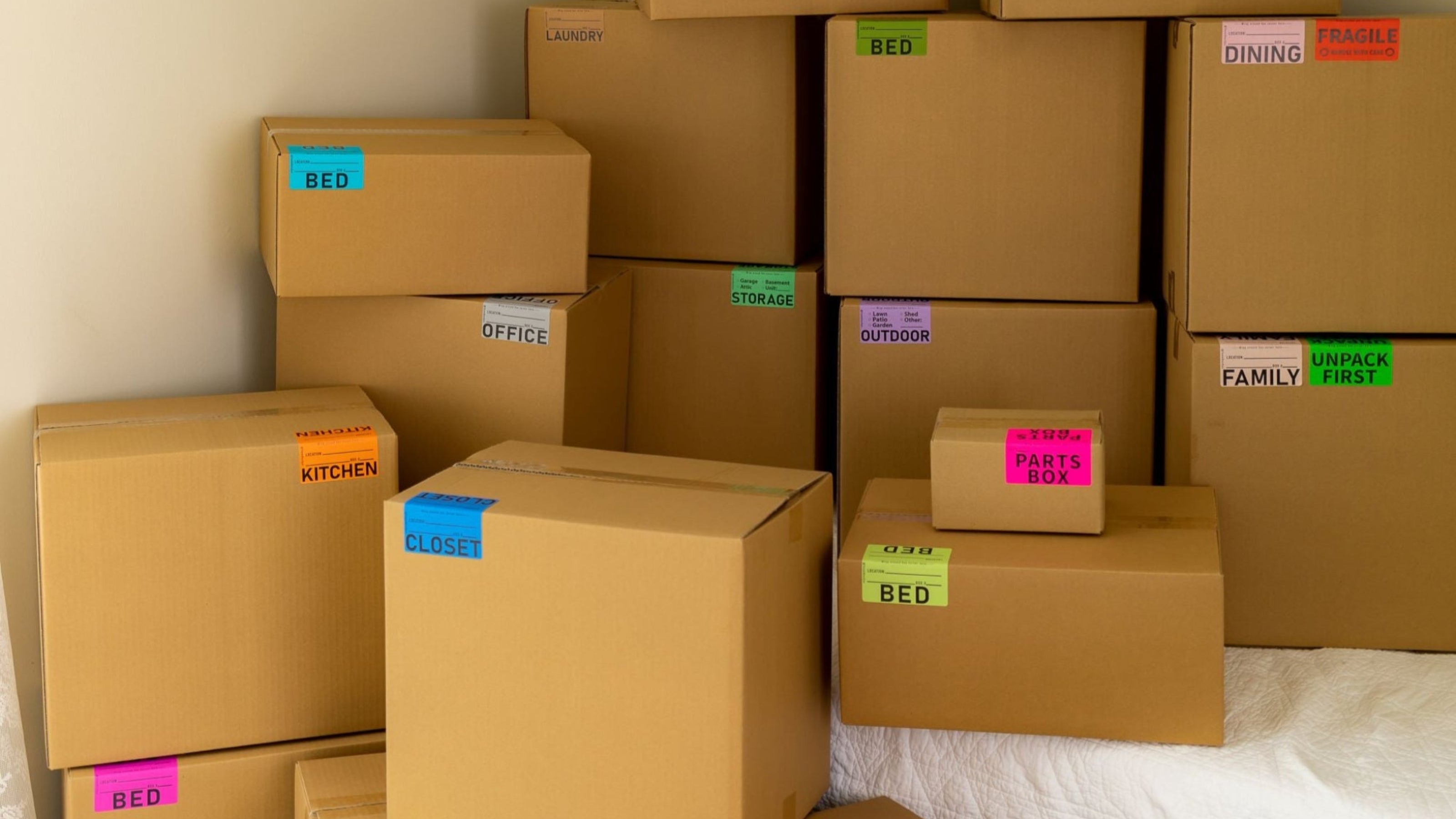 stack of brown moving boxes labeled with color coded moving stickers by BoxOps
