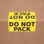 Yellow 'DO NOT PACK' label on a cardboard moving box