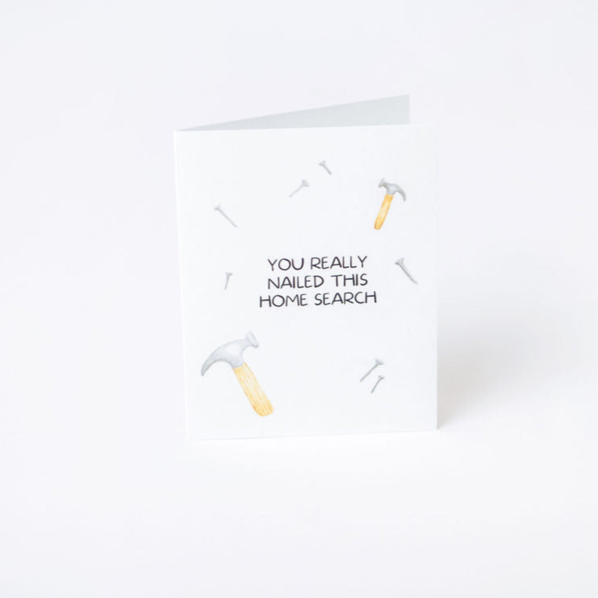 Greeting card with text 'You really nailed this home search' on a white background