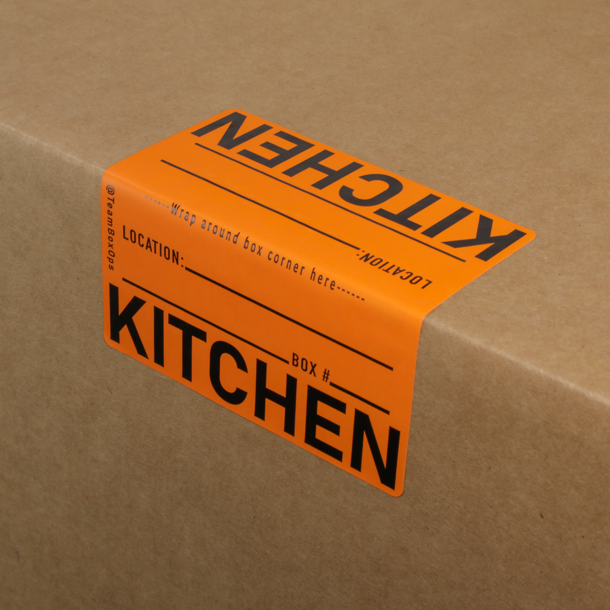 Orange moving label with 'KITCHEN' text on a cardboard box