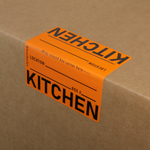Orange moving label with 'KITCHEN' text on a cardboard box