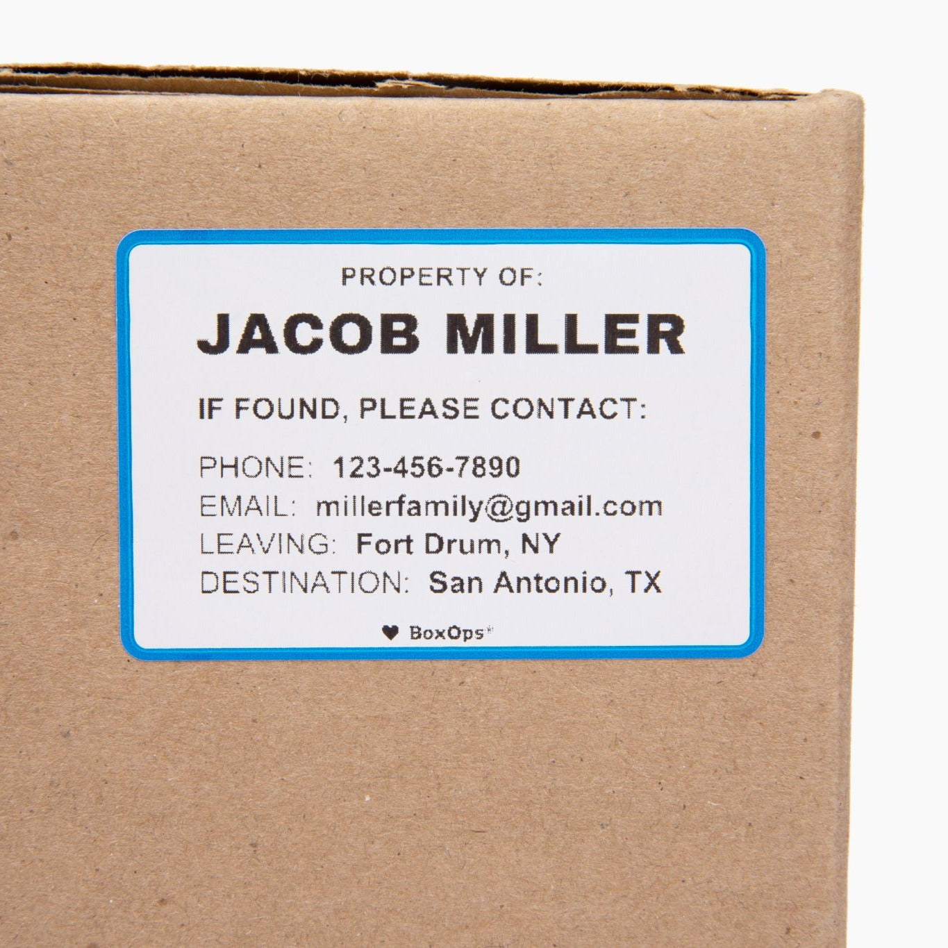 White moving box label with a blue border with a name and contact information for missing moving boxes.
