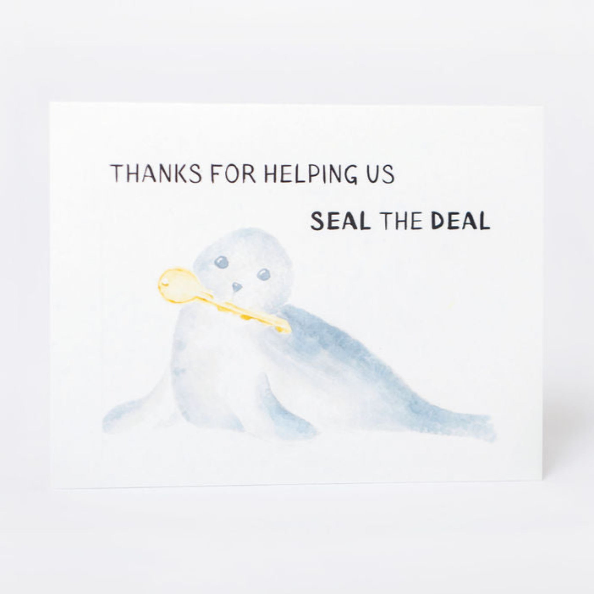 Greeting card with an illustration of a seal with a key and text reading 'Thanks for helping us seal the deal' on a white background
